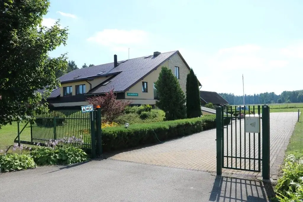 Viesu nama ēka ar zaļiem vārtiņiem